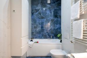 a bathroom with a tub and a toilet and a sink at Giacosa, 71 – Comodo appartamento per 6 in Milan +25 photos
