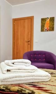 una camera con una sedia viola e un letto di Porta Terra Apartment a Cefalù
