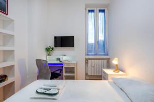 a white bedroom with a desk and a bed and a chair at Giacosa, 71 – Comodo appartamento per 6 in Milan
