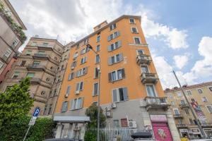 a tall orange building in front of some buildings at Giacosa, 71 – Comodo appartamento per 6 in Milan