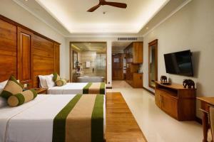 two beds in a hotel room with a television at Araliya Beach Resort & Spa Unawatuna- Where you meet the sea all year in Unawatuna