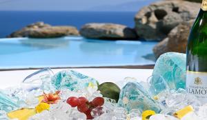 a bottle of wine and some ice and flowers on a table at 6 bedrooms villa at Platis Gialos 800 m away from the beach with sea view private pool and enclosed garden in Paradise Beach