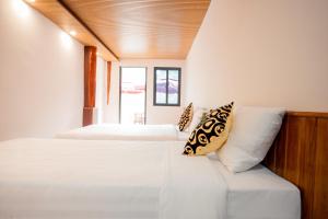 a bedroom with two beds and a couch at Cat Ba Island Garden Homestay - Papillon in Cat Ba