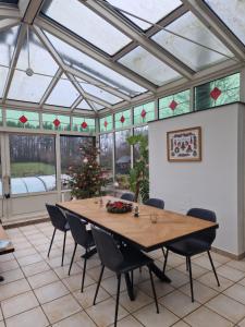 a conservatory with a table and chairs and a christmas tree at Habitat in Momignies