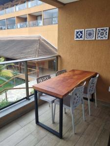 een houten tafel en stoelen in een kamer met een gebouw bij Flat Eco Resort-Praia dos Carneiros in Tamandaré