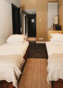 two beds in a hotel room with a hallway at Zoomers aan het Bos in Castricum