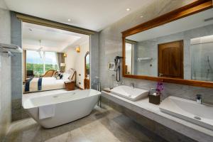 a bathroom with two sinks and a large mirror at Araliya Beach Resort & Spa Unawatuna- Where you meet the sea all year in Unawatuna