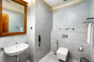 a bathroom with a sink and a toilet and a mirror at Araliya Beach Resort & Spa Unawatuna- Where you meet the sea all year in Unawatuna