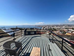 a balcony with a bench and a view of the city at En el corazon del Cerro Alegre in Valparaíso