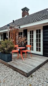 un patio con tavolo e sedie su una casa di Zoomers aan het Bos a Castricum