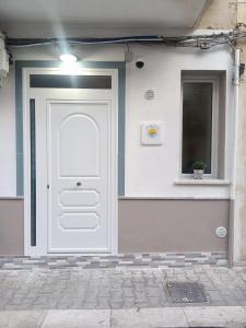a white door on a building with a window at Summer House in Isola delle Femmine
