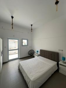 Habitación blanca con cama y ventana en WaveBreeze Villas en Pafos
