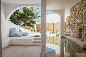ein Wohnzimmer mit Sofa und Kamin in der Unterkunft Aloni Hotel & Suites in Piso Livadi