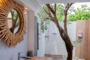 a bathroom with a mirror next to a tree at Exceptional villa with pool and spa, Saint-Barthélemy. in Saint Barthelemy +34 photos
