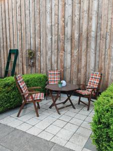 a patio with two chairs and a wooden table and two chairs at Ferienhaus Fachwerk 99 in Stolberg +18 photos