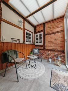 a room with two chairs and a table and a brick wall at Ferienhaus Fachwerk 99 in Stolberg
