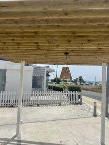 a wooden pavilion with a white fence and a light at WaveBreeze Villas in Paphos City