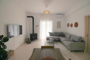 a living room with a couch and a tv at Jasmine Sol Retreat in Delvinë