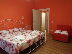 a bedroom with a bed and a red wall at La casa della Pieve Vecchia in Marmigliaio