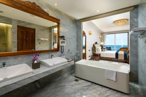 a bathroom with two sinks and a large mirror at Araliya Beach Resort & Spa Unawatuna- Where you meet the sea all year in Unawatuna