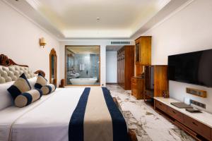 a bedroom with a large bed with a flat screen tv at Araliya Beach Resort & Spa Unawatuna- Where you meet the sea all year in Unawatuna