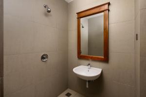 a bathroom with a sink and a mirror at Araliya Beach Resort & Spa Unawatuna- Where you meet the sea all year in Unawatuna