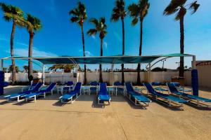 a group of blue lounge chairs and palm trees at Long Island Village Unit 111 in Port Isabel