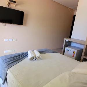 a bedroom with a bed with towels on it at Pousada Solar Dos Carneiros in Praia dos Carneiros
