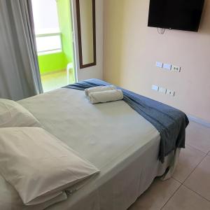 a bed with two towels sitting on top of it at Pousada Solar Dos Carneiros in Praia dos Carneiros