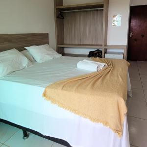 a large bed with a blanket on top of it at Pousada Solar Dos Carneiros in Praia dos Carneiros