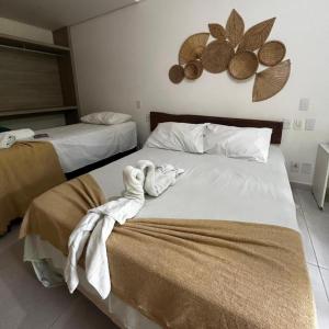 two beds in a hotel room with towels on them at Pousada Solar Dos Carneiros in Praia dos Carneiros