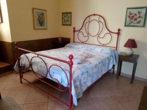 a bed with a red frame in a room at B&B Le Buche Casa Storica in Canino
