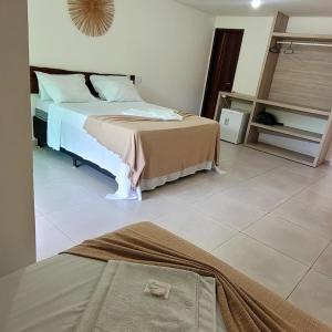 a bedroom with a bed and a tiled floor at Pousada Solar Dos Carneiros in Praia dos Carneiros