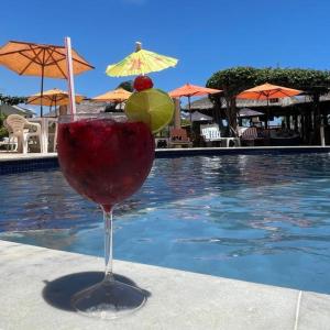 a drink sitting on a table next to a swimming pool at Pousada Solar Dos Carneiros in Praia dos Carneiros