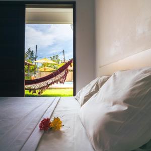 a bedroom with a bed with a flower on it at Pousada Solar Dos Carneiros in Praia dos Carneiros