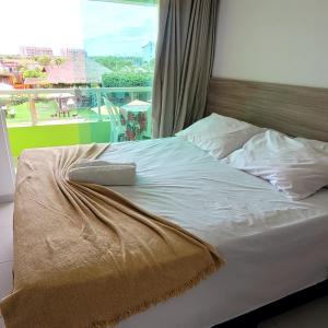 a bed with a remote control on top of it at Pousada Solar Dos Carneiros in Praia dos Carneiros +37 photos