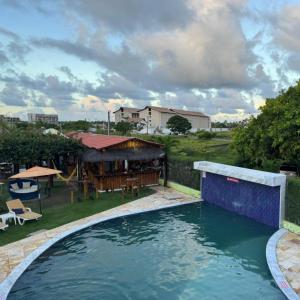 a large swimming pool in a yard with a house at Pousada Solar Dos Carneiros in Praia dos Carneiros
