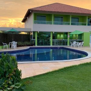 a house with a swimming pool in front of a building at Pousada Solar Dos Carneiros in Praia dos Carneiros