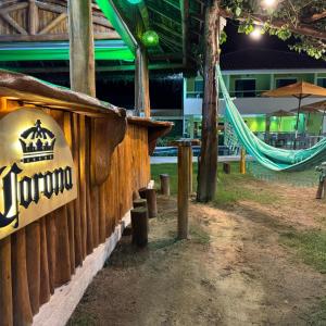 a sign for a hotel with a hammock in a park at Pousada Solar Dos Carneiros in Praia dos Carneiros