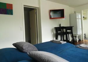 um quarto com 2 camas com lençóis azuis e um frigorífico em H&M Homes Apartments em Aarhus