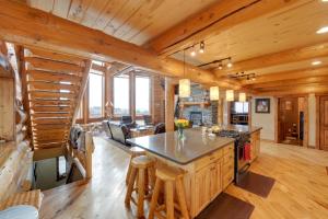 cocina y sala de estar con escalera en una cabaña de madera en Luxe Lodge in the Tetons for Large Group Retreats! en Newdale