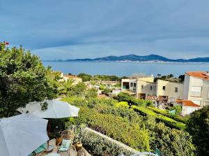 a view of a town with an umbrella and the water at Maison 4 pièces PIETROSELLA in Pietrosella +16 photos