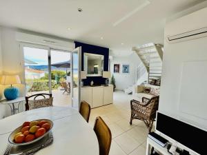 a living room with a table with a bowl of fruit on it at Maison 4 pièces PIETROSELLA in Pietrosella