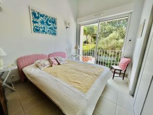 a bedroom with a bed and a large window at Maison 4 pièces PIETROSELLA in Pietrosella