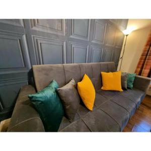 um sofá castanho com quatro almofadas coloridas em Stylish 1 Bed Flat in the Heart of Marble Arch em Londres