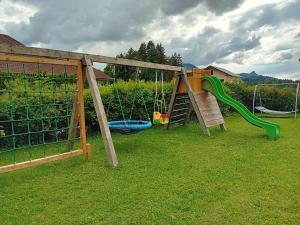 a playground with a slide and a swing at Ferienhof Kehlbauer in Hof bei Salzburg