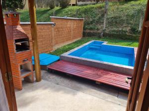 - une piscine avec un banc à côté d'un four en briques dans l'établissement Chalés da Estrada Velha, à Tiradentes