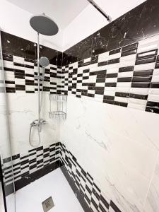y baño blanco y negro con ducha. en Luxury Ocean View Apartment 6th floor, en Los Cristianos