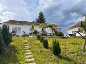 Country House Hățăgel في Hăţăgel: بيت ابيض وامامه حديقه