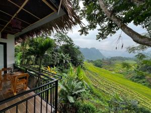 a balcony with a view of a field and mountains at Puluong Aroma in Hương Bá Thước